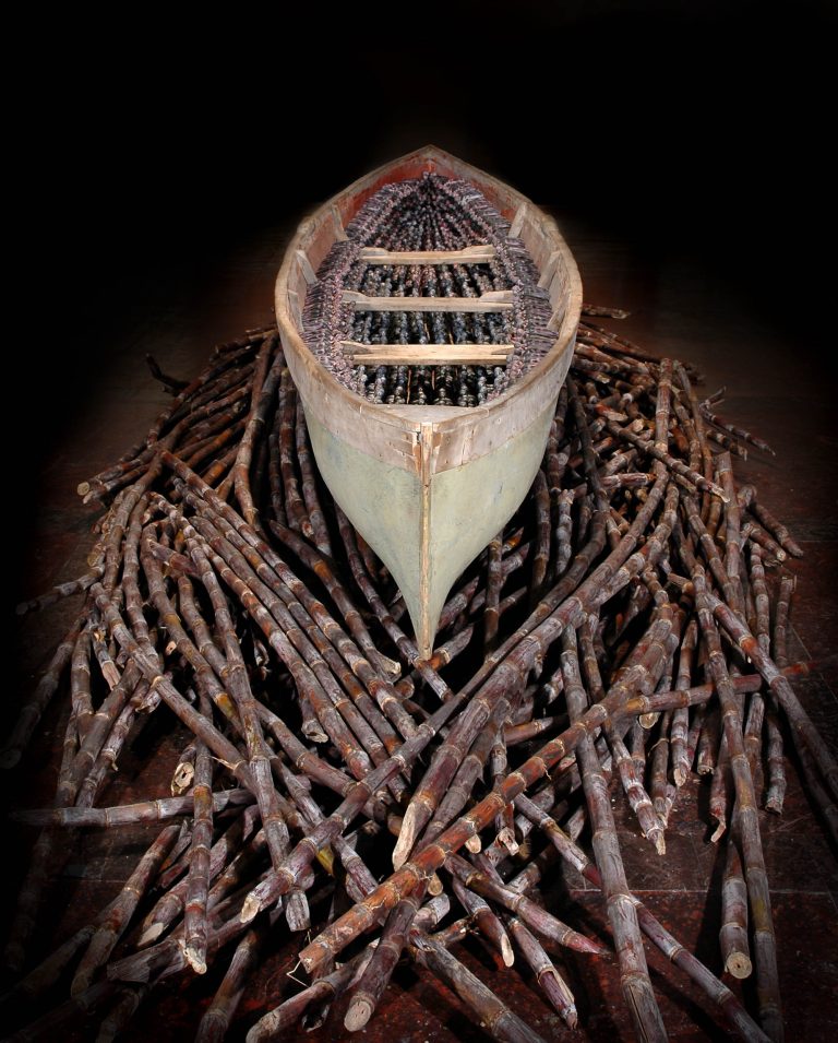 THEIR SPIRITS GONE BEFORE THEM, 2006, cottonwood canoe, 16’; 1357 resin figures, sugar cane