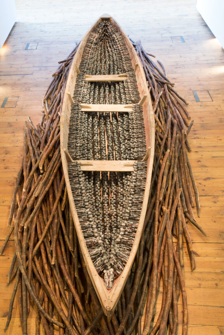 THEIR SPIRITS GONE BEFORE THEM, 2006, cottonwood canoe, 16’; 1357 resin figures, sugar cane